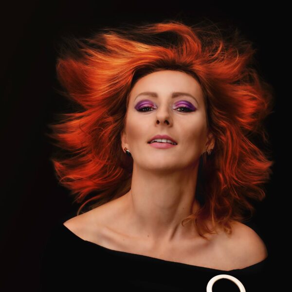kobieta w bardzo mocnym makijażu z rudymi rozwianymi włosami
