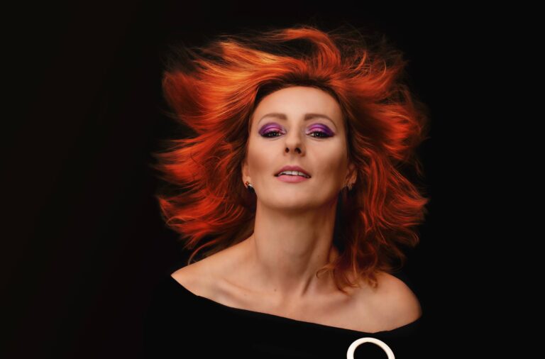 kobieta w bardzo mocnym makijażu z rudymi rozwianymi włosami
