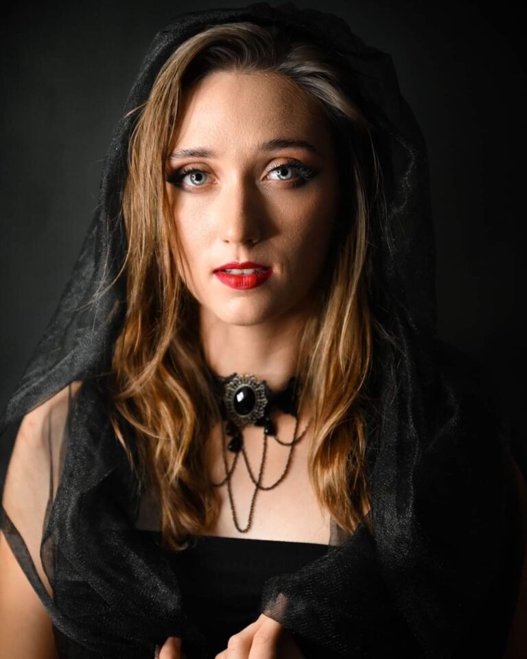 kobieta w mocnym makijażem w czawnym welonie w stylu gotyckim