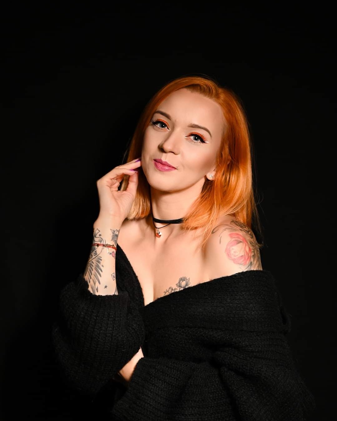 kobieta w mocnym makijażu z rudymi włosami na czarnym tle