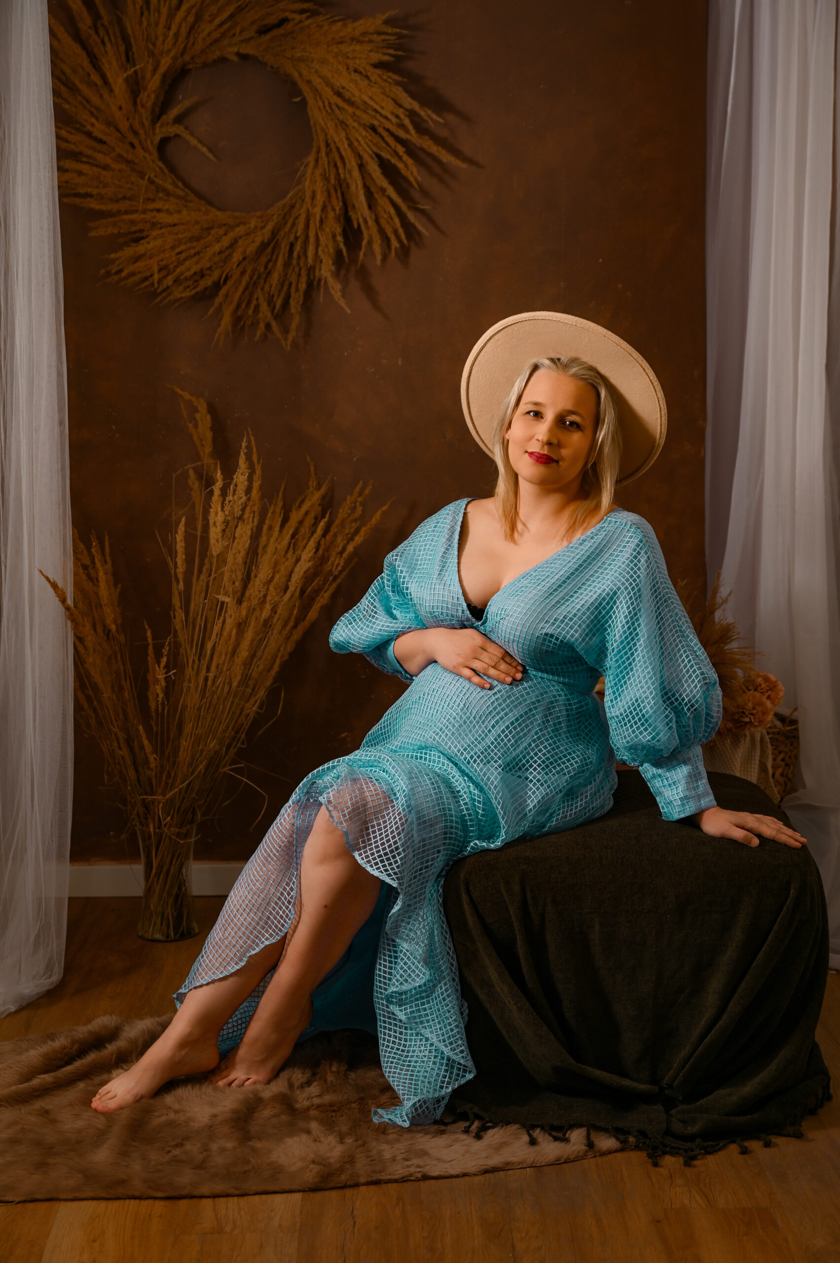 kobieta w nieskiej sukience w ciąży w sesji boho