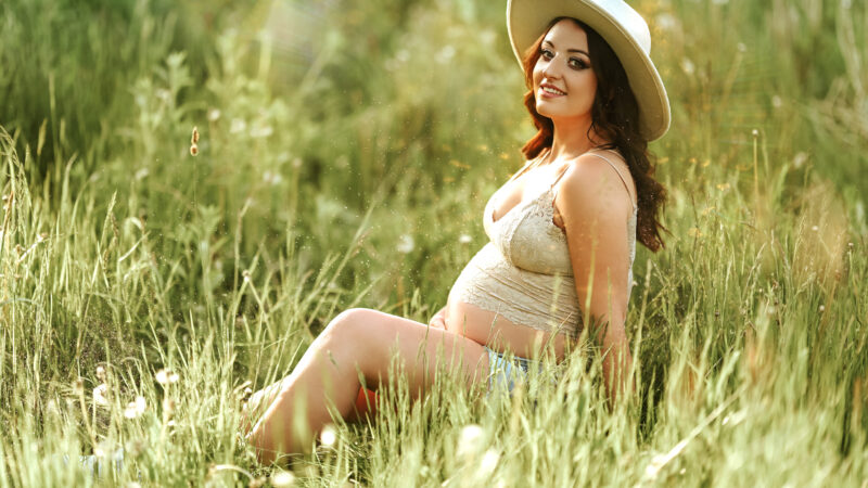 kobieta w ciąży siedząca na łące