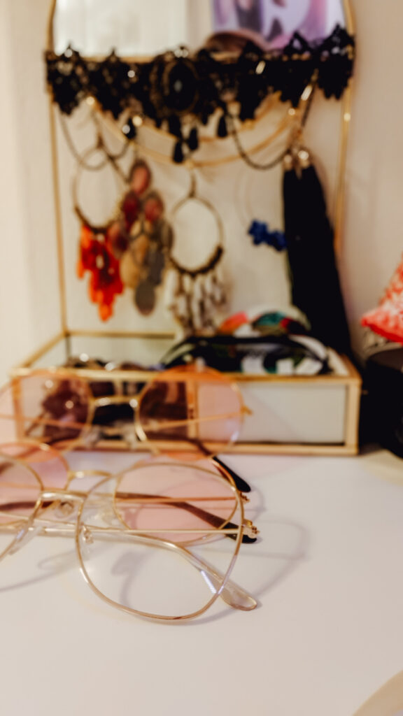 biżuteria leżąca w szkatułce oraz kilka par różnych okularów